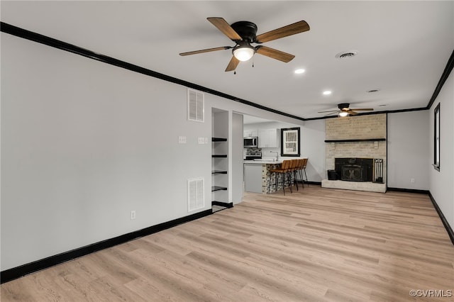 unfurnished living room with light wood-style flooring, visible vents, and crown molding