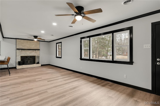 unfurnished living room featuring baseboards, light wood finished floors, visible vents, and crown molding