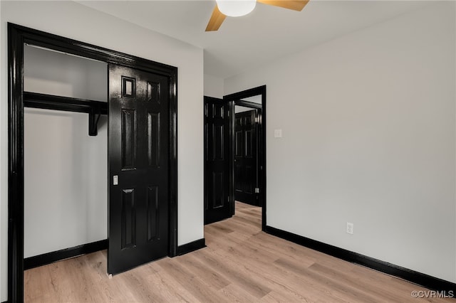 bedroom featuring light wood-style floors, a ceiling fan, baseboards, and a closet