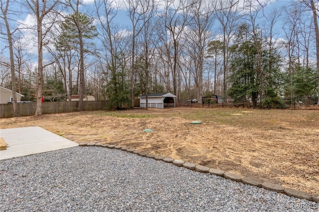 view of yard featuring a pole building, a patio area, fence, and an outdoor structure