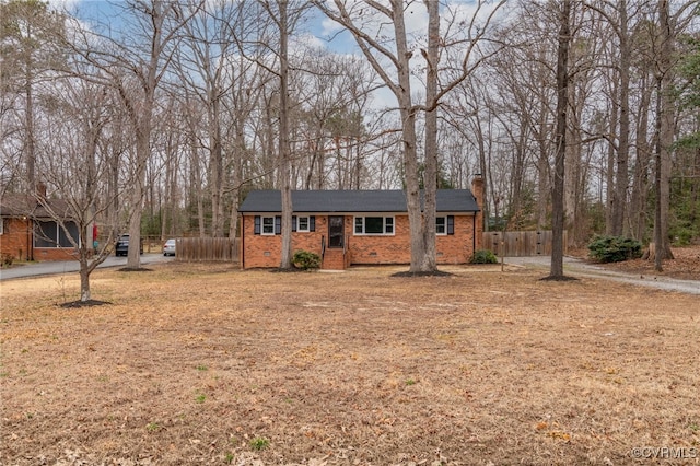 ranch-style home with brick siding, crawl space, a chimney, and fence