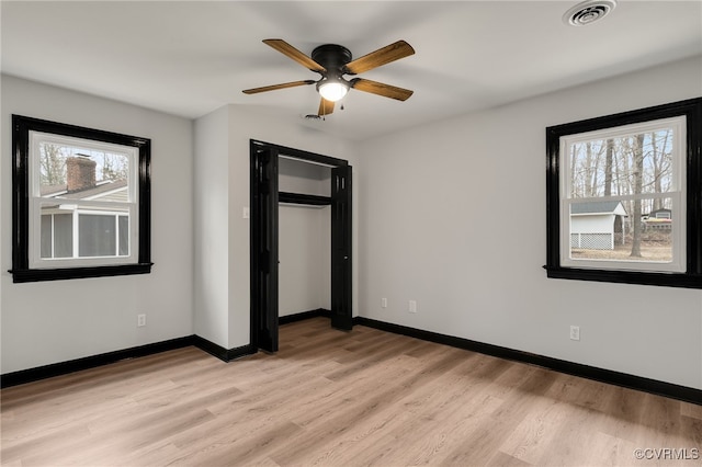 unfurnished bedroom featuring ceiling fan, light wood finished floors, visible vents, and baseboards