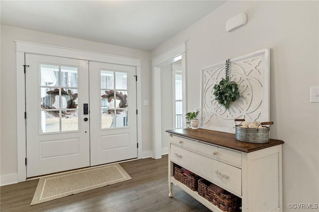 foyer with dark wood-style floors, french doors, and baseboards