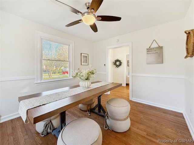 dining area with light wood-style flooring, baseboards, and a ceiling fan