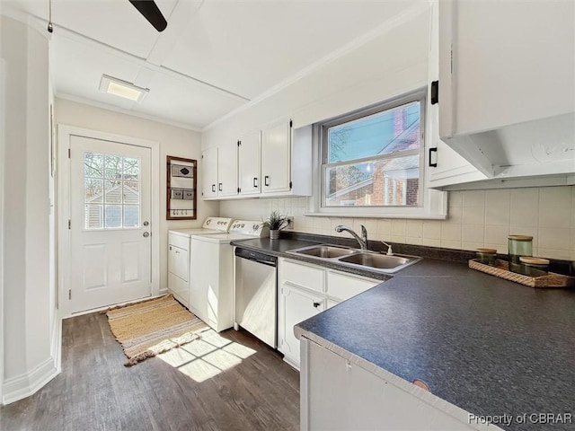 kitchen with dishwasher, dark countertops, independent washer and dryer, white cabinetry, and a sink