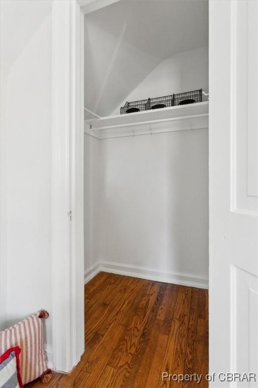 spacious closet with lofted ceiling and wood finished floors