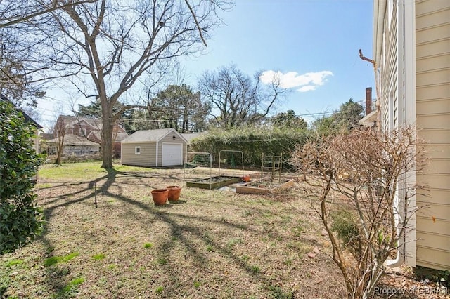 view of yard featuring an outbuilding, a storage shed, and a vegetable garden