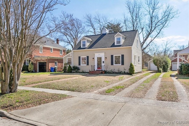 new england style home with an outdoor structure, driveway, roof with shingles, a chimney, and a front yard