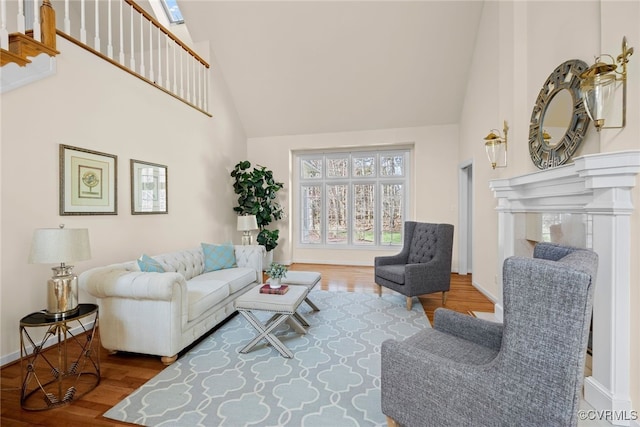 living room with baseboards, high vaulted ceiling, and wood finished floors