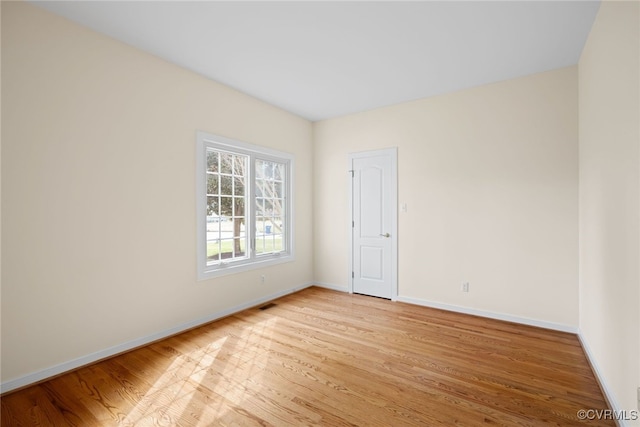 empty room with baseboards and light wood finished floors