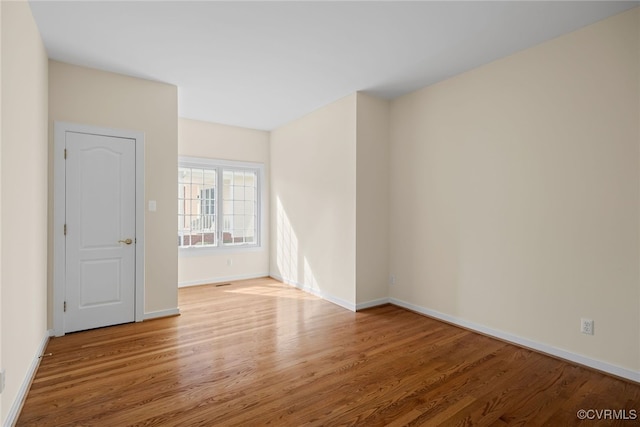 empty room featuring baseboards and wood finished floors