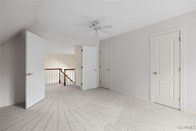 interior space featuring lofted ceiling, carpet flooring, ceiling fan, and baseboards