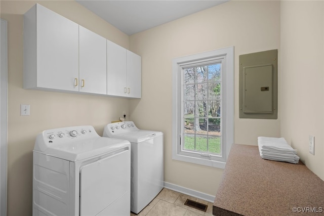 clothes washing area with a healthy amount of sunlight, cabinet space, washing machine and dryer, and electric panel