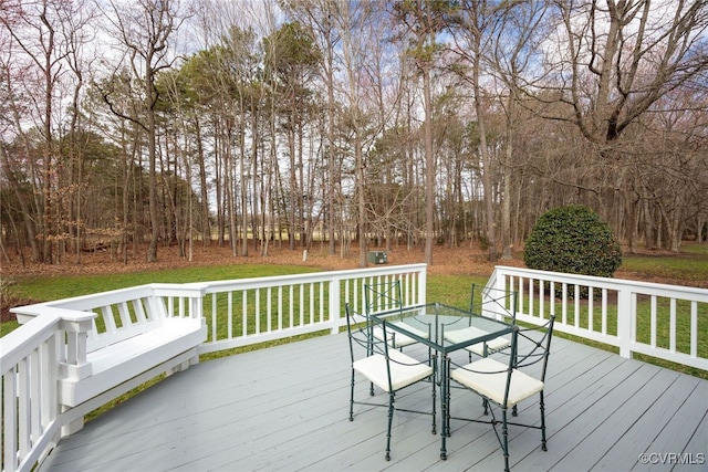 deck with outdoor dining space and a yard