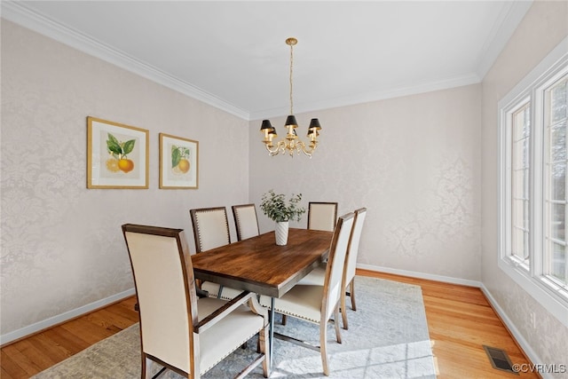 dining space with crown molding, light wood-type flooring, visible vents, and baseboards