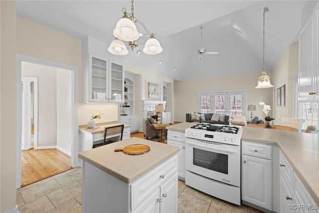 kitchen with open floor plan, plenty of natural light, light tile patterned flooring, and white range with gas cooktop