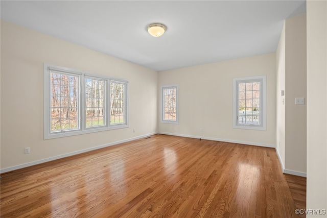 spare room featuring light wood-style flooring and baseboards