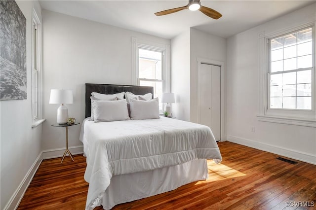 bedroom featuring wood-type flooring, visible vents, and baseboards