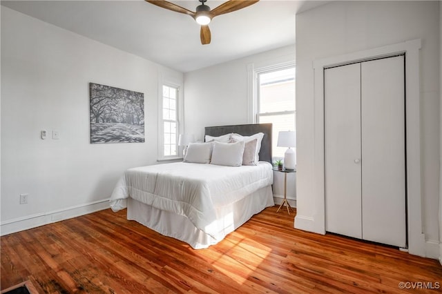 bedroom featuring wood finished floors, a ceiling fan, and baseboards