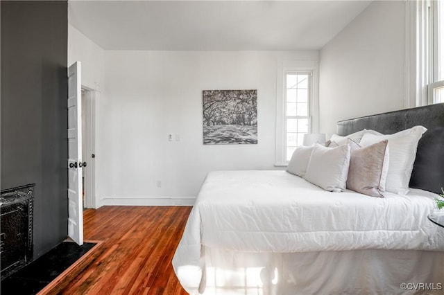 bedroom with dark wood finished floors and baseboards