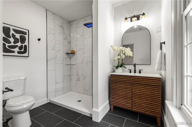 bathroom featuring toilet, a tile shower, baseboards, and tile patterned floors