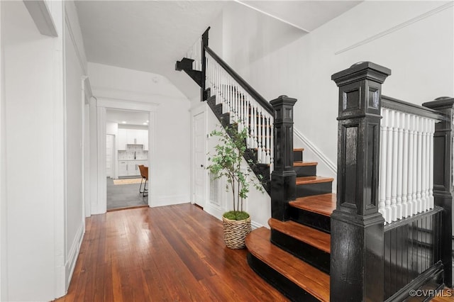 stairway with baseboards and hardwood / wood-style flooring