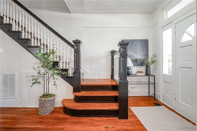 foyer featuring stairs, visible vents, and wood finished floors