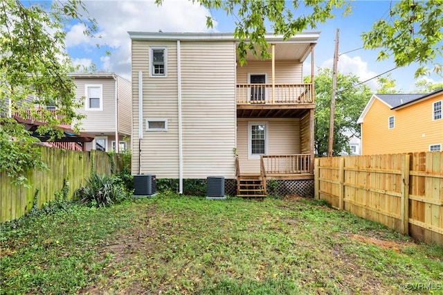 rear view of house with a wooden deck, a fenced backyard, central AC unit, and a balcony