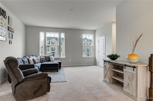 living area with baseboards and light colored carpet