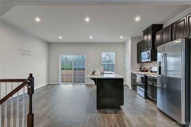 kitchen with stainless steel appliances, recessed lighting, light countertops, dark wood-type flooring, and a sink