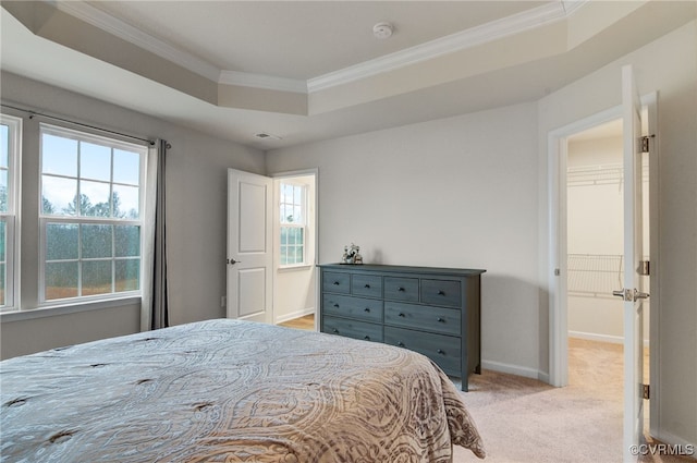 bedroom with a raised ceiling, light colored carpet, visible vents, ornamental molding, and baseboards