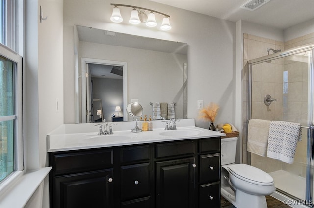 full bath with a stall shower, visible vents, a sink, and double vanity