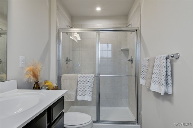 full bathroom with a stall shower, vanity, and toilet