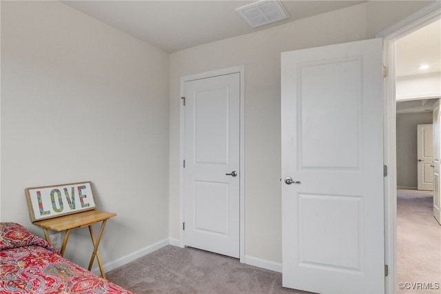 bedroom with baseboards, visible vents, and light colored carpet