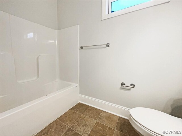 full bathroom featuring toilet, bathing tub / shower combination, and baseboards