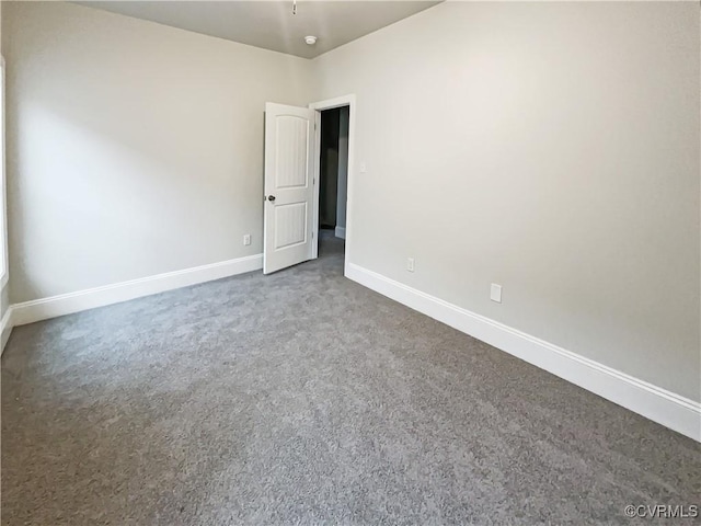 spare room featuring carpet flooring and baseboards