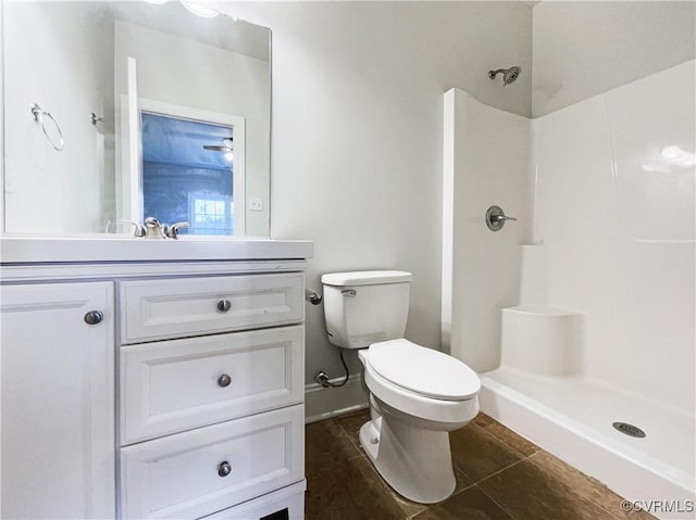 bathroom with tile patterned flooring, vanity, toilet, and walk in shower