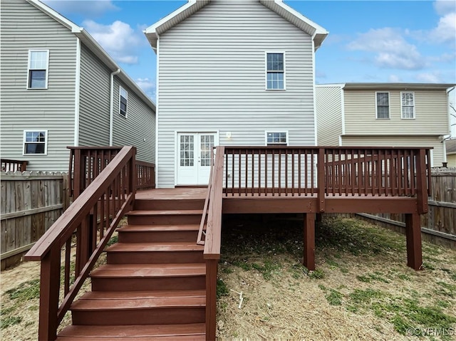 rear view of house with stairway, fence, french doors, and a wooden deck