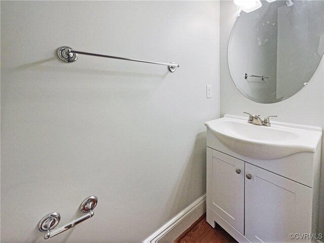 bathroom with baseboards, wood finished floors, and vanity