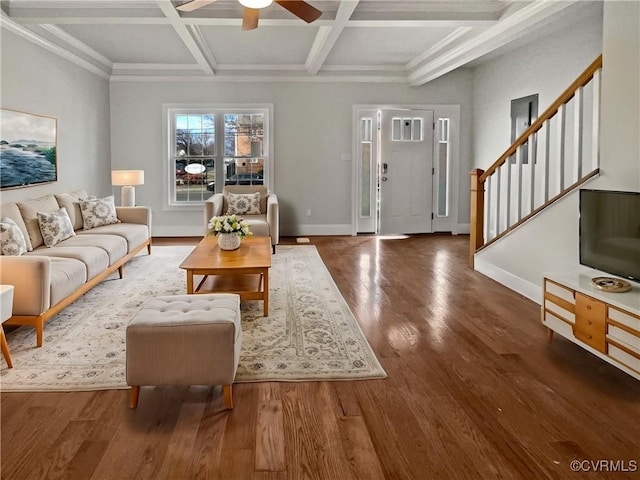 living area with beam ceiling, wood finished floors, coffered ceiling, baseboards, and stairs