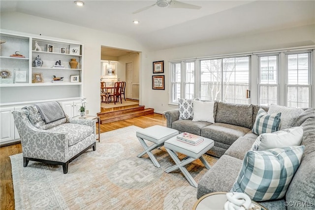 living room featuring lofted ceiling, light wood-style floors, a healthy amount of sunlight, and ceiling fan