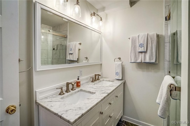 bathroom featuring a sink, baseboards, tiled shower, and double vanity