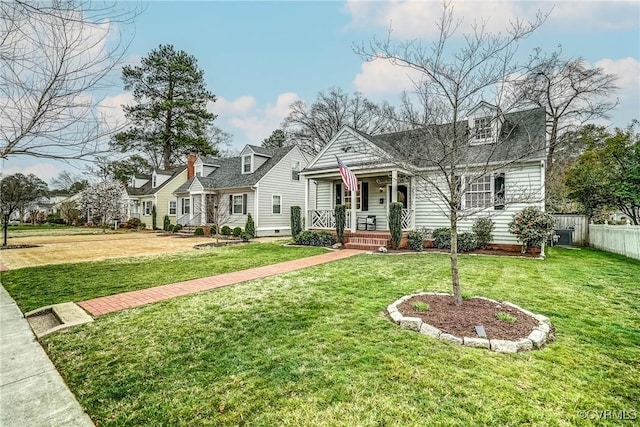 cape cod home with a porch, fence, and a front lawn