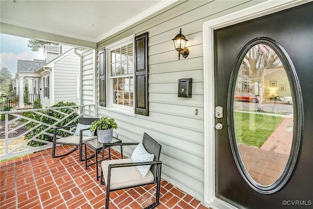 view of exterior entry featuring covered porch