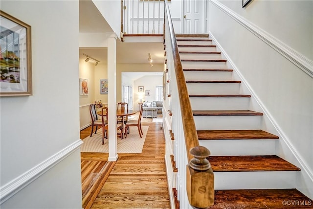 stairway with baseboards and wood finished floors