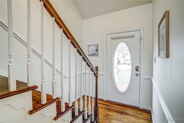 foyer featuring stairs, baseboards, and wood finished floors