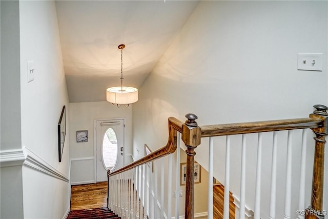 stairs with vaulted ceiling and wood finished floors