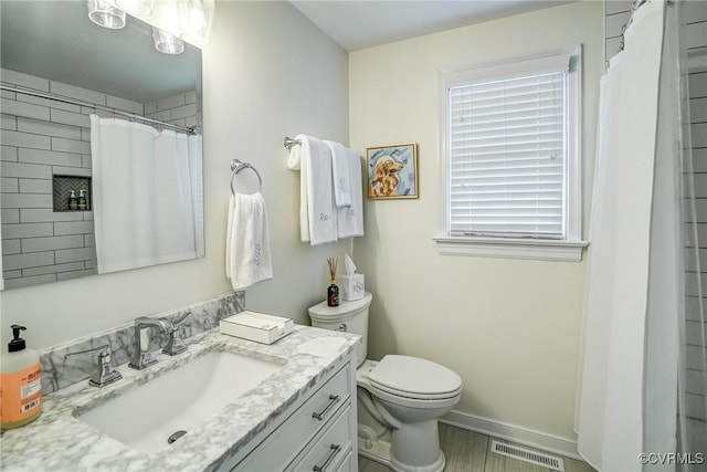 bathroom featuring visible vents, baseboards, toilet, a shower with curtain, and vanity