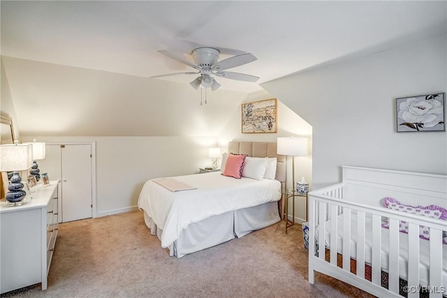 bedroom featuring baseboards, light colored carpet, a ceiling fan, and vaulted ceiling