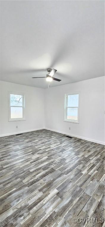 spare room with baseboards, a ceiling fan, and wood finished floors